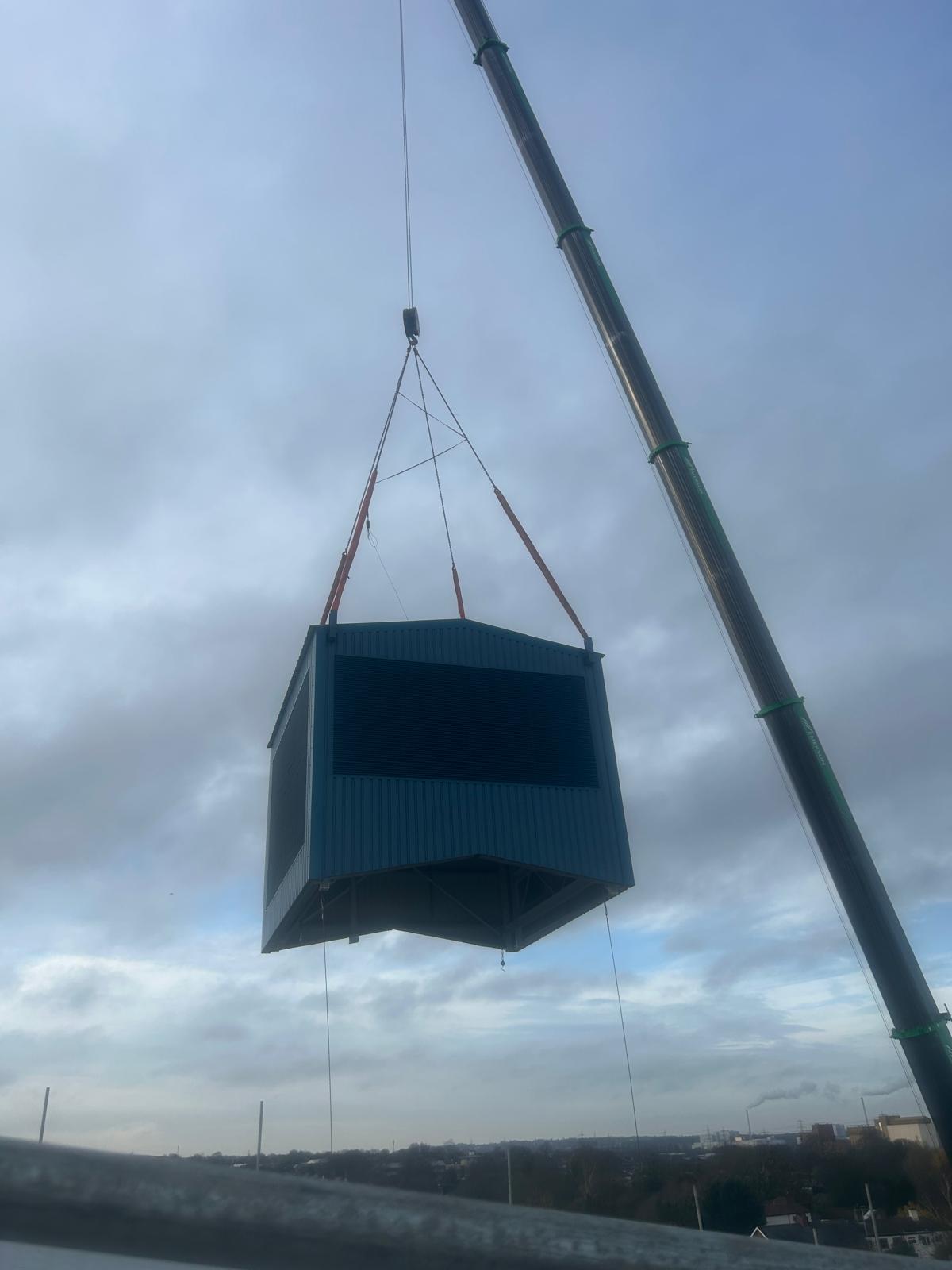 Crane lifting completed structure into position